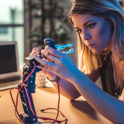 Young woman working in a robotics workshop.